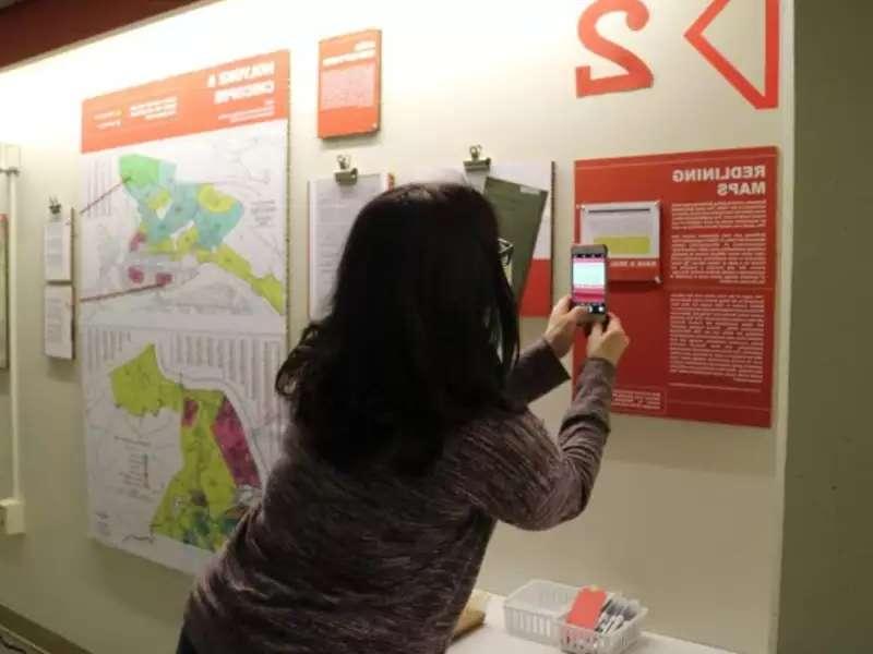 Individual taking picture of the Undesign the Redline exhibit